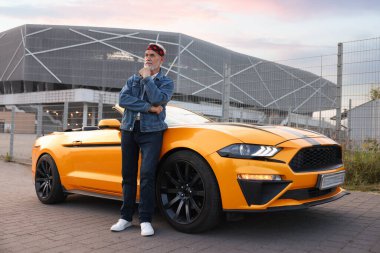 Modern Cabriolet yakınlarında şık bir kıdemli adam.