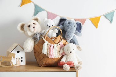 Beyaz duvarın yanındaki ahşap masada farklı oyuncaklar.