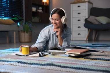 Kulaklıklı mutlu öğrenci evde sınava hazırlanıyor.