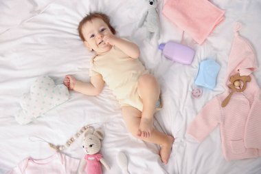 Güzel bebek ve yatağın üstünde farklı aksesuarlar.