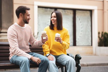 Paket kahve. Şehir caddesinde kağıt bardakta içki içen çift, mesaj için yer.