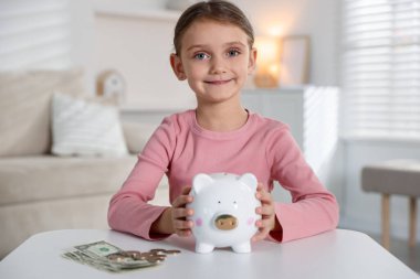 Cep harçlığı ve kumbarası olan küçük bir kız.