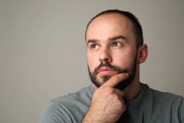 Kellik sorunu. Gri arka planda ince çizgileri olan düşünceli bir adam. Metin için boşluk