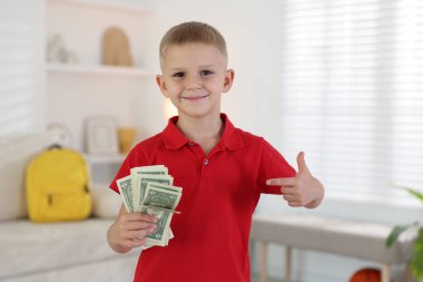 Evde cep harçlığı tutan küçük çocuk.