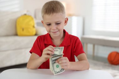 Beyaz masada cep harçlığı tutan küçük çocuk.