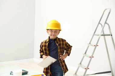 Meslek seçimi. Spatula aletli küçük çocuk içeride inşaatçı gibi davranıyor.