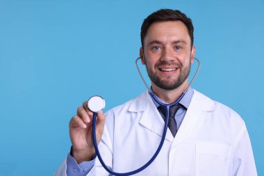 Açık mavi arka planda steteskobu olan bir çocuk doktoru.