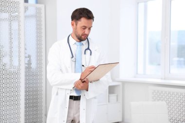 Hastanedeki steteskopu ve panosu olan bir çocuk doktoru.