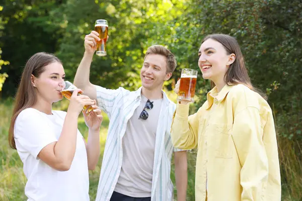 Bir grup mutlu arkadaş dışarıda bira içip eğleniyorlar.