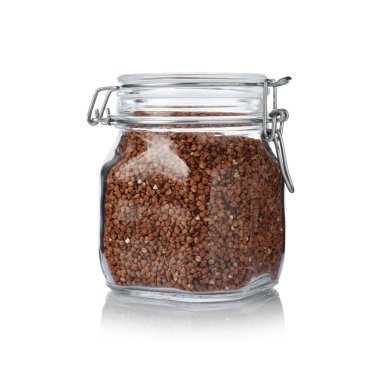Glass jar with raw buckwheat isolated on white