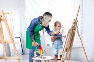 Meslek seçimi. Anne kızına stüdyoda resim yapmayı öğretiyor.