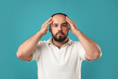 Kellik sorunu. Açık mavi arkaplanda saç çizgisi olan bir adamın portresi