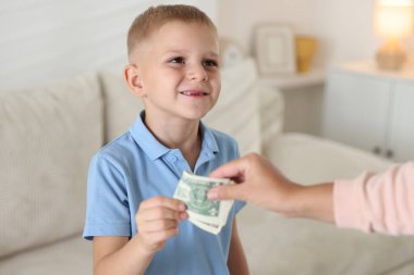 Anne evdeki oğluna harçlık veriyor, yakın plan.