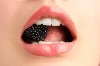 Güzel dudaklı ve böğürtlenli kadın, yakın plan.