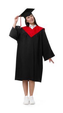 Mezuniyet elbisesi ve beyaz arka planda havan panosu olan mutlu genç kadın.