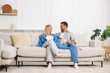 Evdeki koltukta klimalı uzaktan kumandalı bir çift.