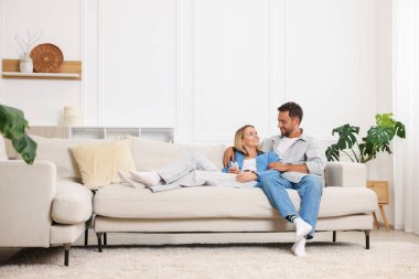 Mutlu çift evdeki kanepede birlikte vakit geçiriyor. Metin için boşluk