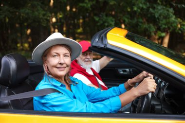 Üst düzey bir çift açık havada eğleniyor, seçici bir odak noktası var.