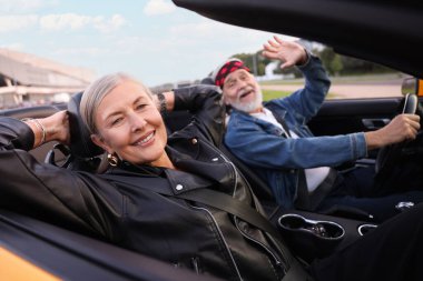 Şık bir son sınıf çifti. Cabriolet sürüşünden zevk alıyor. Seçici bir odak noktası.