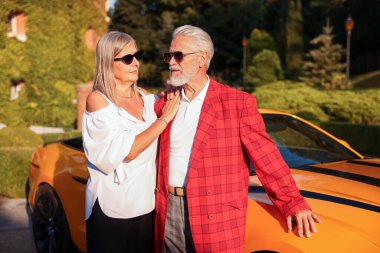 Modern Cabriolet yakınlarında güneş gözlüklü şık bir çift.