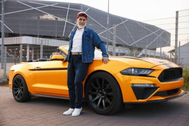 Modern Cabriolet yakınlarında şık bir kıdemli adam.