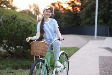 Şehir caddesinde bisiklet süren mutlu bir kadın. Metin için boşluk