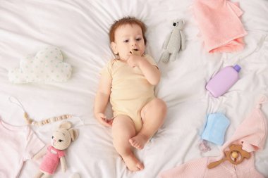 Güzel bebek ve yatağın üstünde farklı aksesuarlar.