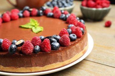 Lezzetli çikolatalı kek, böğürtlenli ve nane şekerli, ahşap masa, yakın plan.