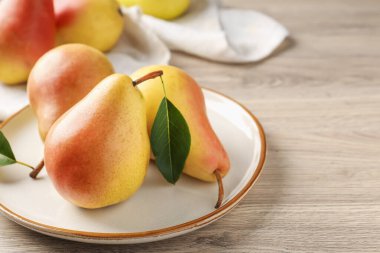 Fresh ripe pears on wooden table, closeup. Space for text