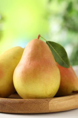 Taze olgun armutlar beyaz ahşap masa üzerinde, yakın plan.