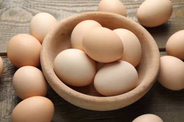 Fresh chicken eggs on wooden table, closeup