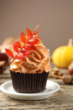 Gri arka planda, üzerinde kırmızı yapraklar olan lezzetli bir kek, yakın plan. Sonbahar atmosferi