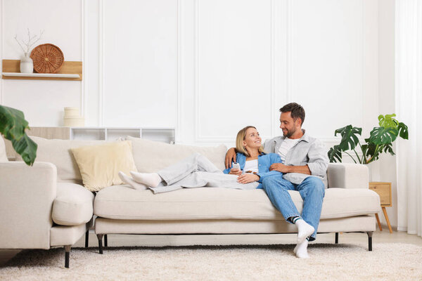 Счастливая пара проводит время вместе на диване дома. Пространство для текста