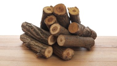 Ahşap masa üzerine kesilmiş odun yığını beyaz arka plana karşı