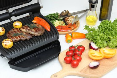 İçerideki beyaz tezgahta lezzetli et, sebze ve yağlı ızgara.