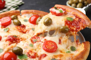 Peynirli, domatesli ve zeytinli lezzetli bir pizza.