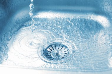 Water going down sink drain, closeup view