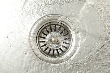 Water going down sink drain, top view