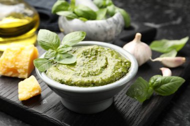 Kâsede taze pesto sosu ve siyah masada malzemeler, yakın plan.