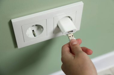 Kadın USB adaptörüne kablo yerleştiriyor.