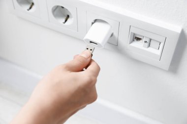 Kadın USB adaptörüne kablo yerleştiriyor.