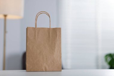 Beyaz masa içerisindeki kağıt alışveriş torbası. Metin için boşluk