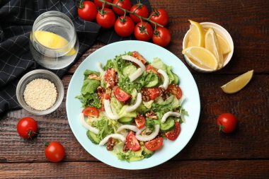 Ahşap masada servis edilen kalamar, sebze ve cevizli nefis salata.