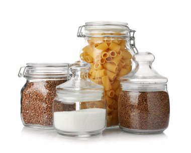 Glass jars with different products isolated on white