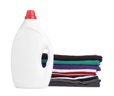Çamaşır deterjanıyla dolu bir şişe ve beyaza izole edilmiş giysiler.