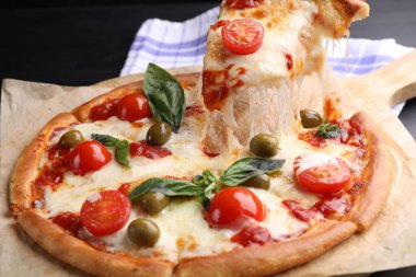 Peynirli, domatesli ve zeytinli lezzetli bir pizza.