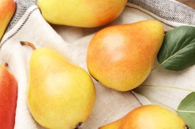 Masanın üstünde taze armut ve peçete var.