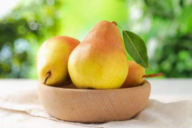 Taze olgun armutlar beyaz masada kasede, yakın plan.