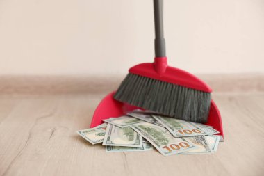 Dolar banknotları olan faraş ve kapalı alanda süpürge, yakın plan. Metin için boşluk