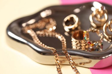 Renkli arka planda şık altın mücevherler, yakın plan